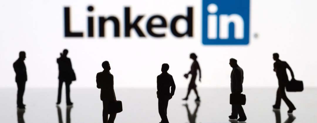 İstanbul, Turkey - February 12, 2014: Human figurines standing in front of Apple iPad monitor displaying LinkedIn logo. LinkedIn is a social networking service for people in professional occupations.